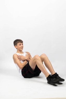 On beş yaşında, beyaz bir arka planda film çeken, mekik çeken bir çocuk.