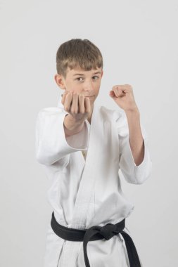15 yaşında, erkek, karate kara kuşağı Uraken Uchi yapıyor. Stüdyo çekimi beyaz bir arkaplanda.