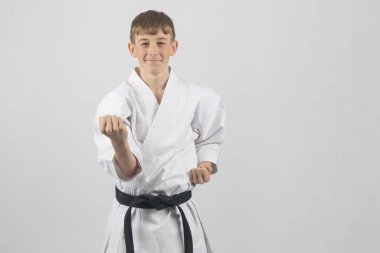 15 yaşında, erkek, karate karatesi, siyah kuşak vücut bloğu. Stüdyo, beyaz bir arka plana karşı.
