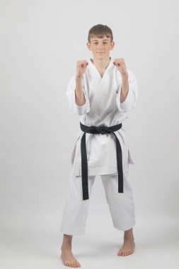 15 yaşında, erkek, karate, siyah bel, Sanchin duruşu, arka yumruk, stüdyo çekimi, beyaz arka plan.