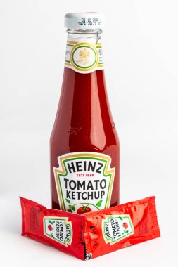 Londra, Birleşik Krallık 10 Mart 2025 - Heinz Domates Ketçap Sachets ve Heinz Organik Domates Ketçap Şişesi. Beyaz Geçmişe Karşı Stüdyo Çekimi.