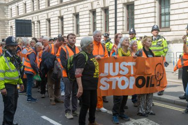 Londra, Birleşik Krallık, 26 Nisan 2025 - Just Stop Oil üyeleri, kampanyalarında başarılı olduklarını iddia ettikten sonra son kez Londra 'da protesto yaptılar. Bir bayrak tutarak