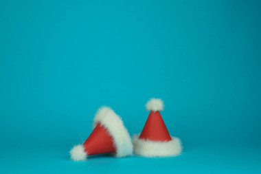 Yeşil arka planda beyaz tüylü şapkalı iki Noel Baba kırmızısı. Minimum stil kart. Yüksek kalite fotoğraf