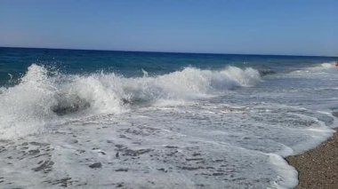 2023 'te Yunanistan' ın Girit adasındaki kumlu bir plaja köpüren dalgaların yavaş çekim görüntüleri. Yüksek kaliteli HD görüntüler