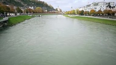 Salzburg, Avusturya. Nehir boyunca yürürken, gün batımını seyrederken. Yüksek kaliteli video