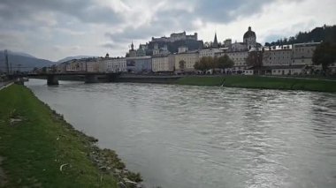Salzburg, Avusturya. Nehir boyunca yürürken, gün batımını seyrederken. Yüksek kaliteli video