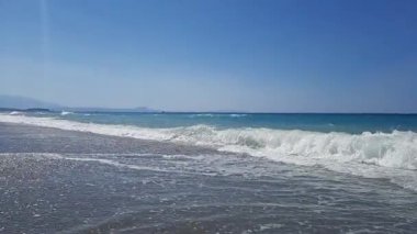 Ağustos 2023 'te Yunanistan' ın Girit adasındaki kumlu bir plaja köpüren dalgaların yavaş çekim görüntüleri. Yüksek kaliteli HD görüntüler