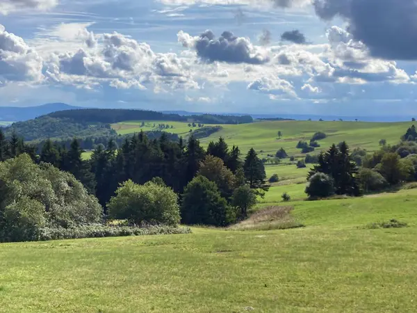 Rhoen, Hesse, Almanya 'nın güzel kırsal kesiminin manzarası. Güneşli bir öğleden sonra. Dağlardaki harika bahar manzarası. Çimen tarlaları ve yuvarlanan tepeler. Kırsal alan. Yüksek kalite fotoğraf