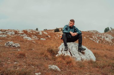 Yürüyüş rotasından sonra dinlenen yorgun bir erkek yürüyüşçü. Yüksek kalite fotoğraf