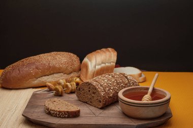 Sağlıklı bir kahvaltı, tam tahıllı ekmek, meyve ve arılardan elde edilen organik bal ve siyah arka planda izole edilmiş ahşap masa. - Evet. Yüksek kalite fotoğraf