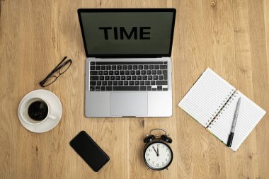 İş zamanı konsepti, ekran dizüstü bilgisayarı, bardaklar, kahve, defter, saat, telefon, dizüstü bilgisayar, ahşap masa manzarası. Yüksek kalite fotoğraf