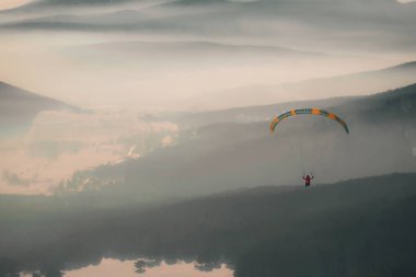 Paragliding konsepti, bir paraglider pilotu doğa dağ manzarası arka planında gökyüzünde uçar. Yüksek kalite fotoğraf