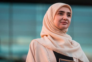 Ofis binasının yakınında tesettürlü, kendine güvenen Müslüman bir iş kadınının portresi. Yüksek kalite fotoğraf