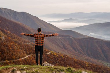 Bir gezgin, dağın tepesine elini kaldırarak bakmaktan zevk alır. Macera seyahati. Yüksek kalite fotoğraf