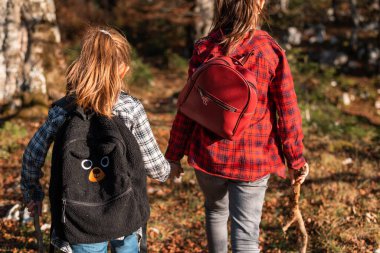 Çocuklar sonbahar ormanlarında yürüyüş sırasında birlikte yürüyorlar, aile macerası seyahati. Yüksek kalite fotoğraf