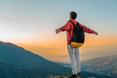 Dağın zirvesinde elini kolunu açmış, mutlu bir gezgin özgürce seyahat ediyor. Yüksek kalite fotoğraf