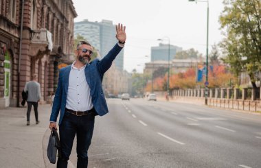 Yakışıklı, olgun bir iş adamı şehirde taksiye biner. Yüksek kalite fotoğraf