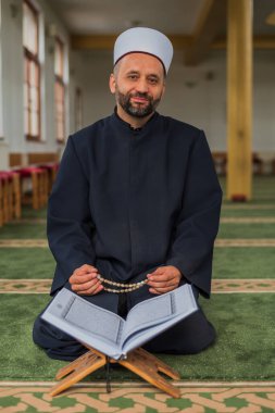 Cami içinde Kur 'an-ı Mübarek' in kutsal kitabıyla dua eden bir müslüman. - Evet. Yüksek kalite fotoğraf