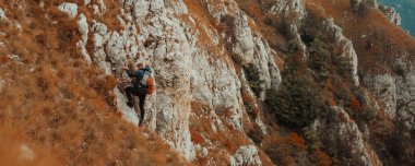 Erkek bir dağcı dağa tırmanıyor, macera yolculuğu, adrenalin ekstrem spor, spor afişi, cesaret ve korkusuzluk kavramı. Yüksek kalite fotoğraf