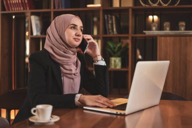 Genç Müslüman bir iş kadını ofiste çalışırken telefonla konuşuyor. - Evet. Yüksek kalite fotoğraf