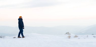 Karlı bir dağda yürüyen orta yaşlı bir adam. Kış dönemi. Yüksek kalite fotoğraf