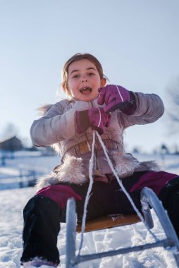 Gülümseyen bir çocuk kızağı. Mutlu bir kış tatili ve karda oynama kavramı. Yüksek kalite fotoğraf