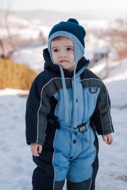 Küçük şirin bir çocuk, kışlık giysiler giymiş bir çocuk. Yüksek kalite fotoğraf