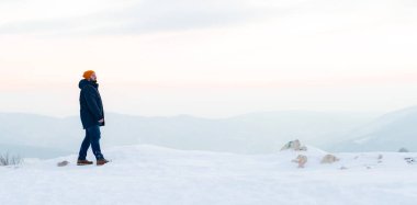 Karlı bir dağda yürüyen orta yaşlı bir adam. Kış dönemi. Yüksek kalite fotoğraf