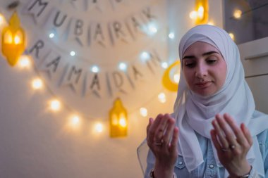 Arka planda Mübarek Ramazan süslemesiyle dua eden Müslüman bir kadın resmi. - Evet. Yüksek kalite fotoğraf
