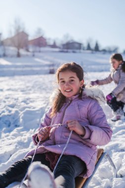 Gülümseyen bir çocuk kızağı. Mutlu bir kış tatili ve karda oynama kavramı. Yüksek kalite fotoğraf