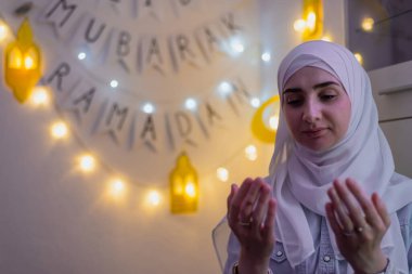 Arka planda Mübarek Ramazan süslemesiyle dua eden Müslüman bir kadın resmi. - Evet. Yüksek kalite fotoğraf
