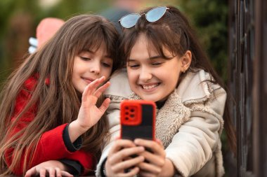 Dışarıda cep telefonu kullanan iki mutlu arkadaş. Yüksek kalite fotoğraf
