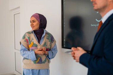 Kurumsal iş semineri için iş arkadaşlarıyla toplantı ya da toplantı odasında. Üniversite öğretmeni sınıfta cevap veren Müslüman öğrenciyi dinliyor. Yüksek kalite fotoğraf