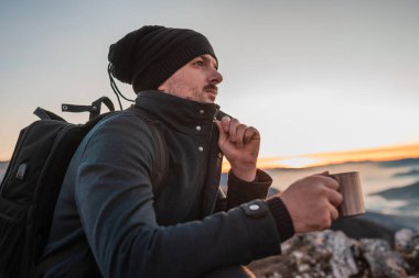 Turist bir adam, dağda aktif ve sağlıklı bir yaşam tarzı macera yolculuğu sırasında bir fincan kahve veya çay içerken dinleniyor. - Evet. Yüksek kalite fotoğraf