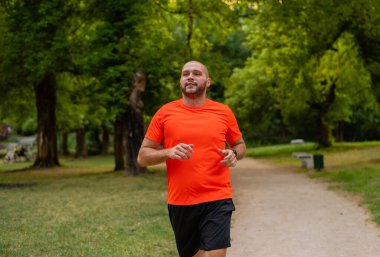 Sportif bir adam parkta koşuyor ya da koşuyor. Yüksek kalite fotoğraf