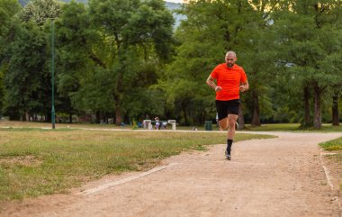 Sportif adam parkta koşuyor ya da koşuyor. Yüksek kalite fotoğraf