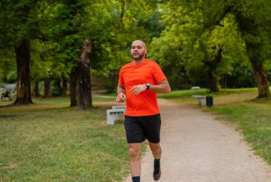 Sportif bir adam parkta koşuyor ya da koşuyor. Yüksek kalite fotoğraf