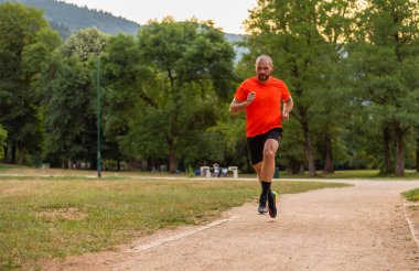 Sportif adam parkta koşuyor ya da koşuyor. Yüksek kalite fotoğraf