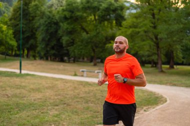 Sportif bir adam parkta koşuyor ya da koşuyor. Yüksek kalite fotoğraf