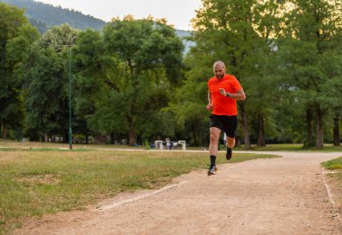 Sportif adam parkta koşuyor ya da koşuyor. Yüksek kalite fotoğraf