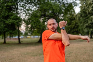 Sportif bir adam koşmadan önce esneme egzersizleri yapıyor ya da yaz parkında egzersiz yapıyor. Aktif, sağlıklı bir yaşam tarzı. - Evet. Yüksek kalite fotoğraf