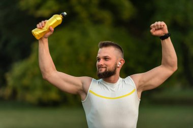 Başarılı bir koşudan sonra genç ve güçlü bir adam yumruğunu kaldırdı. Spor zaferi kavramı, zafer. Yüksek kalite fotoğraf