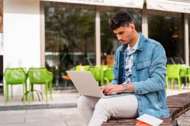 Bir erkek üniversite öğrencisi ya da bir kafede dizüstü bilgisayar kullanan serbest çalışan genç bir adam. Yüksek kalite fotoğraf