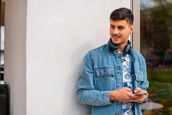 Şehir caddesinde cep telefonu kullanan mutlu, genç bir adam. Yüksek kalite fotoğraf