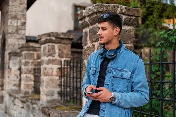 Şehir caddesinde cep telefonu kullanan mutlu, genç bir adam. Yüksek kalite fotoğraf