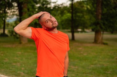 Sportif bir adam koşmadan önce esneme egzersizleri yapıyor ya da yaz parkında egzersiz yapıyor. Aktif, sağlıklı bir yaşam tarzı. - Evet. Yüksek kalite fotoğraf