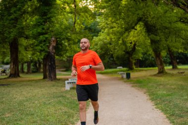 Sportif bir adam parkta koşuyor ya da koşuyor. Yüksek kalite fotoğraf