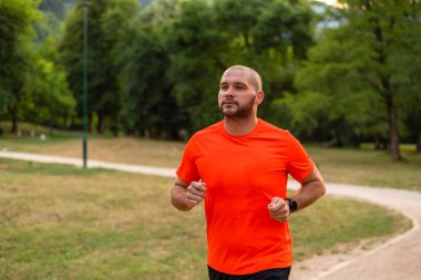 Sportif bir sporcu parkta koşuyor ya da koşuyor, aktif ve sağlıklı bir yaşam tarzı var. Yüksek kalite fotoğraf