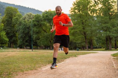 Parkta koşan atletik bir adam, aktif ve sağlıklı bir yaşam tarzı var. Yüksek kalite fotoğraf