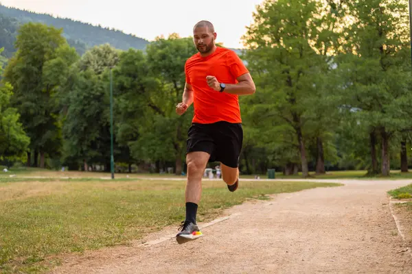 Parkta koşan atletik bir adam, aktif ve sağlıklı bir yaşam tarzı var. Yüksek kalite fotoğraf